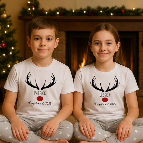 Two children wearing matching shirts with antlers and names in front of a fireplace and Christmas tree.
Personalised Lapland holiday PJs for families – cosy Christmas Lapland pyjamas that double as a Lapland trip reveal outfit, matching Lapland holiday outfits, and a thoughtful personalised Lapland gift idea.