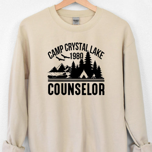 Beige sweatshirt with 'Camp Crystal Lake 1980 Counselor' graphic on a white background